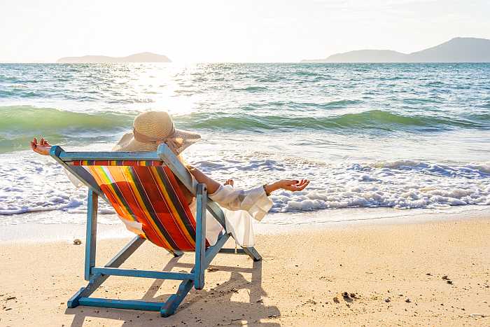 Woman relaxing on the beach (Relax or Seek Adventure).