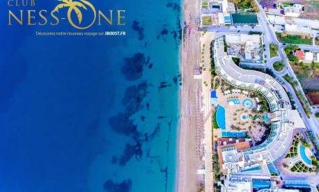Exterior of Club Hotel Casino Loutraki with beachfront location and palm trees in Loutraki, Greece